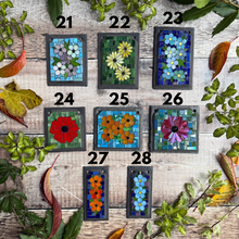 Set of 8 mosaic art pieces on a wooden surface with leaves around